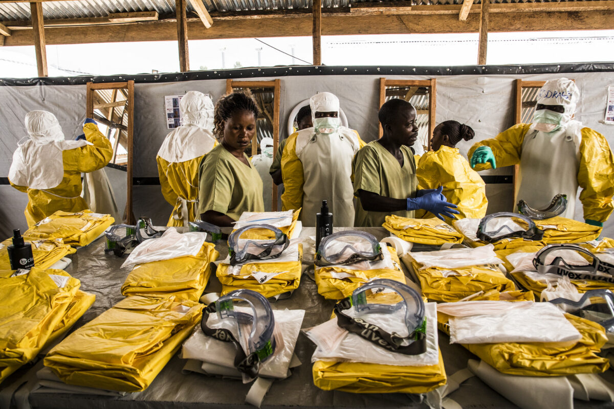 Democratic Republic of Congo. Health workers put their Personal Protective Equipment on before entering the zone where people suspected of having Ebola are held in quarantine to be monitored and treated at the Ebola Transition Center. (World Bank / Vincent Tremeau photo)